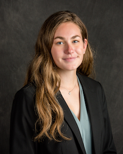 student in business professional attire smiles and poses for a professional headshot